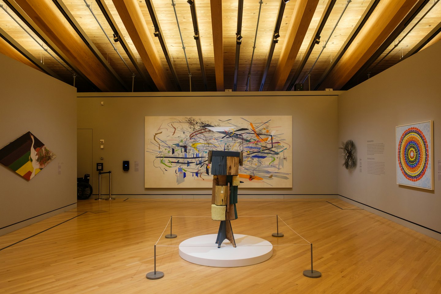 Abstrakte Malerei und Holzskulptur in einer Kunstgalerie.